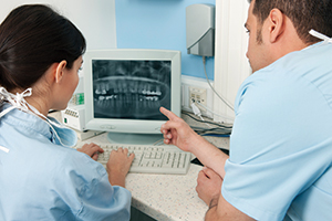 dentists looking at x-rays on a monitor